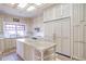 A kitchen featuring an island with stone countertop, appliances, and ample cabinet space under a skylight at 5200 Moore Rd, Suwanee, GA 30024