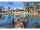 Wooden dock on a calm lake surrounded by trees and featuring a boathouse in the distance at 5200 Moore Rd, Suwanee, GA 30024