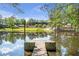 Scenic lake view from the dock with reflections of the sky and trees, showcasing a tranquil waterfront property at 5200 Moore Rd, Suwanee, GA 30024