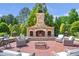Inviting outdoor fireplace with comfortable seating and a brick patio, perfect for entertaining at 5200 Moore Rd, Suwanee, GA 30024