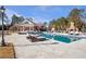 Large in-ground pool with lounge chairs, umbrellas, landscaping, and an outdoor fireplace at 5200 Moore Rd, Suwanee, GA 30024