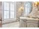 Elegant powder room boasts custom vanity, decorative wallpaper, stylish mirror, and fixtures, a luxurious touch at 5200 Moore Rd, Suwanee, GA 30024