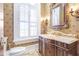 Stylish powder room featuring custom vanity, decorative mirror, sconces, and wallpaper, adding a touch of sophistication at 5200 Moore Rd, Suwanee, GA 30024