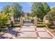 Grand gated entrance with manicured landscaping and a long driveway leading to an estate, highlighting privacy at 5200 Moore Rd, Suwanee, GA 30024