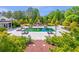 Expansive pool with lounge chairs, surrounded by lush greenery and a charming brick walkway at 5200 Moore Rd, Suwanee, GA 30024