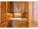 Elegant wet bar featuring dark wood cabinetry, marble countertop, and brass hardware at 5200 Moore Rd, Suwanee, GA 30024