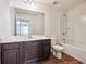 Bathroom vanity featuring dark wood cabinetry, laminate flooring and bathtub with shower at 7247 Emma Ct, Douglasville, GA 30134