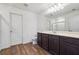 Bathroom featuring wood flooring, a large vanity, a toilet, and a large framed mirror at 7247 Emma Ct, Douglasville, GA 30134