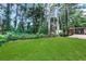 Private backyard with a grassy area and wooded backdrop at 6231 Creekford Dr, Lithonia, GA 30058