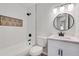 Clean bathroom with white vanity, bathtub, and patterned accent tile at 6231 Creekford Dr, Lithonia, GA 30058