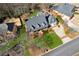 An aerial view of a charming home featuring a welcoming front porch, manicured lawn, and attached two-car garage at 1449 Brentford Cv, Snellville, GA 30078