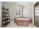 Bathroom features a soaking tub, a window providing natural light, and tiled floors at 1449 Brentford Cv, Snellville, GA 30078