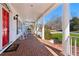 Charming front porch with brick flooring, rocking chairs, and views of the landscaped front yard at 1449 Brentford Cv, Snellville, GA 30078