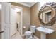 Elegant bathroom with a pedestal sink and decorative mirror at 2950 Mount Wilkinson Se Pkwy # 304, Atlanta, GA 30339