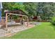 A well-manicured backyard with a covered patio, a fire pit, and green lawns at 930 Custer St, Atlanta, GA 30354