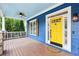 Inviting front porch with a ceiling fan and a vibrant yellow front door, creating a warm entry at 930 Custer St, Atlanta, GA 30354