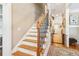 A staircase with hardwood steps and decorative black iron railing leads to the upper level at 930 Custer St, Atlanta, GA 30354