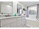 Bathroom showcasing a double vanity, granite countertops, and a separate soaking tub at 320 Windermere Dr, Loganville, GA 30052