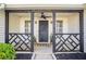 Inviting front porch featuring stylish black accents, decorative railing, and ceiling fan at 320 Windermere Dr, Loganville, GA 30052