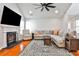 Cozy living room with fireplace, and ceiling fan features hardwood flooring and large sectional at 320 Windermere Dr, Loganville, GA 30052