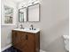 Double vanity bathroom with a wood cabinet, black matte faucets, and square mirrors at 4145 White Oak Dr, Winston, GA 30187