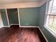 Bedroom featuring hardwood floors, a closet and a large window letting in natural light at 54 Cross Branches, Acworth, GA 30101