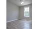 Spacious bedroom with a window, ceiling fan, and wood-look floors at 121 Orchard Dr, Temple, GA 30179