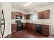 Kitchen with dark brown cabinets, black appliances and granite countertops at 15 Lisa Ct, Covington, GA 30016