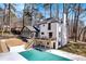 Rear exterior showing a white brick home with a pool, deck, and beautifully landscaped backyard at 7110 Brandon Mill, Sandy Springs, GA 30328