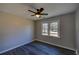 This bedroom features wood-look floors, neutral walls, a ceiling fan, and a window overlooking the outdoors at 3640 Autumn View Nw Dr, Acworth, GA 30101