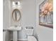 Elegant powder room with pedestal sink, oval mirror, and modern art at 205 Bastian Dr # 2, Villa Rica, GA 30180