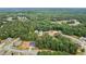 An overhead view shows houses nestled between lush trees in a residential area at 4267 Matisse Ln, Fairburn, GA 30213