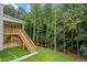 Expansive backyard features a wooden deck, staircase, lush lawn, and natural wooded backdrop at 4267 Matisse Ln, Fairburn, GA 30213