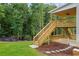 Backyard view showcasing wooden deck and stairs leading to the lush lawn, complemented by wooded backdrop at 4267 Matisse Ln, Fairburn, GA 30213
