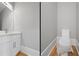 Half-bathroom featuring a white vanity with a quartz countertop and a toilet at 4267 Matisse Ln, Fairburn, GA 30213