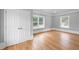 Bedroom with hardwood floors, white trim, natural light from two windows, and closet at 4267 Matisse Ln, Fairburn, GA 30213