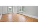 Bedroom with hardwood floors, white trim, natural light from two windows, and closet at 4267 Matisse Ln, Fairburn, GA 30213