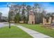 Landscaped community entrance featuring decorative stone tower, manicured lawn, and sidewalk at 4267 Matisse Ln, Fairburn, GA 30213