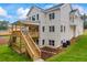 Rear exterior view featuring white brick, a spacious wooden deck and stairs leading to the lush yard at 4267 Matisse Ln, Fairburn, GA 30213