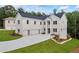 Elegant exterior of a white brick home with a spacious driveway and a three-car garage at 4267 Matisse Ln, Fairburn, GA 30213