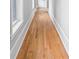 Hallway featuring gleaming hardwood floors, white trim, and natural light from a window at 4267 Matisse Ln, Fairburn, GA 30213