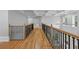 Second floor landing and hallway with coffered ceilings, hardwood floors, and wood with wrought iron railings at 4267 Matisse Ln, Fairburn, GA 30213