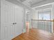 Upstairs hallway with hardwood floors, closet doors, and access to a bedroom through an open doorway at 4267 Matisse Ln, Fairburn, GA 30213