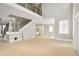 Open-concept living area with high ceilings, a wooden staircase, and abundant natural light at 4267 Matisse Ln, Fairburn, GA 30213
