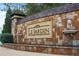 Community signage with stone wall, lion head water feature, and lush landscaping at 4267 Matisse Ln, Fairburn, GA 30213