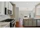 Open kitchen with marble countertops and stainless steel appliances overlooking living room at 2669 Glenrose Hl, Atlanta, GA 30341