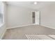 Bright bedroom with window, carpet, and access to hallway at 6897 Estepona St, Atlanta, GA 30349