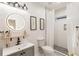 Modern bathroom with a walk-in shower, floating shelves, and a round mirror at 994 Byron Sw Dr, Atlanta, GA 30310