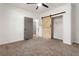 Spacious bedroom with light brown carpet, a barn door, and ceiling fan at 994 Byron Sw Dr, Atlanta, GA 30310