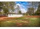 View of the backyard with a shed, trees, and a spacious grassy area at 105 Tranquillity Dr, Villa Rica, GA 30180